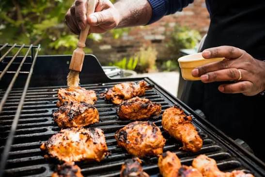 Chef grilling vibrant red tandoori chicken skewers